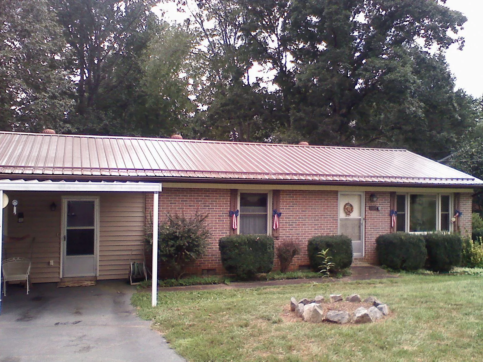 Bronze metal roof and carport on a brick ranch home — Roof Repair work by our crew in Saint John