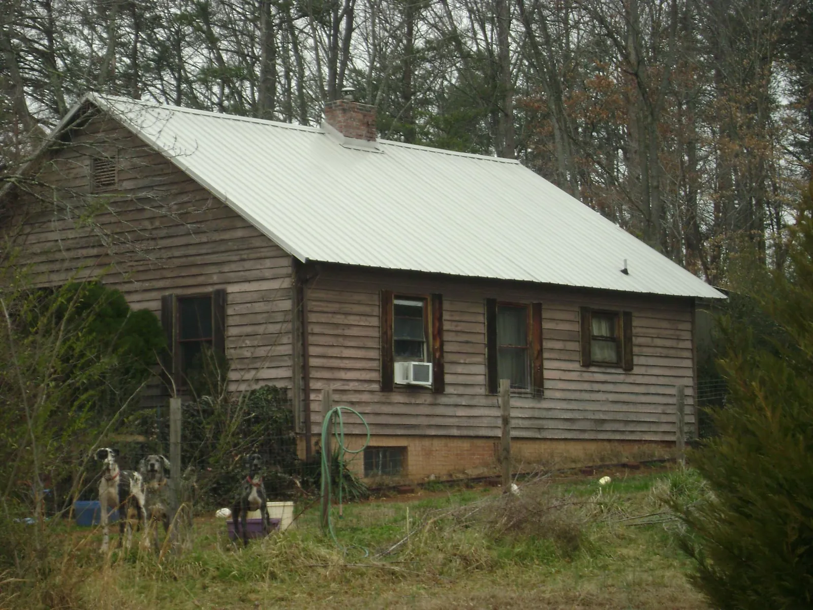 White metal roof on an old wood sided farmhouse, from a Metal Roof Installation job in Saint John